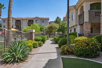 A sunny day in a residential area with a sidewalk and apartment buildings.